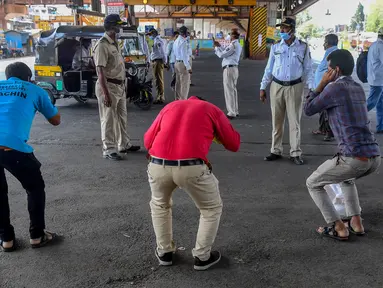 Polisi meminta warga untuk melakukan sit-up sebagai hukuman karena keluar rumah selama pemberlakukan penguncian wilayah (lockdown) di Mumbai, 31 Maret 2020. Pemerintah India menerapkan kebijakan karantina wilayah atau lockdown dalam memerangi Virus Corona COVID-19. (INDRANIL MUKHERJEE/AFP)