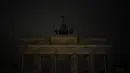 Lampu Gerbang Brandenburg terkenal Jerman dengan Quadriga di atasnya dimatikan untuk menandai Earth Hour di Berlin, Jerman, Sabtu, 25 Maret 2023. (AP Photo/Markus Schreiber)