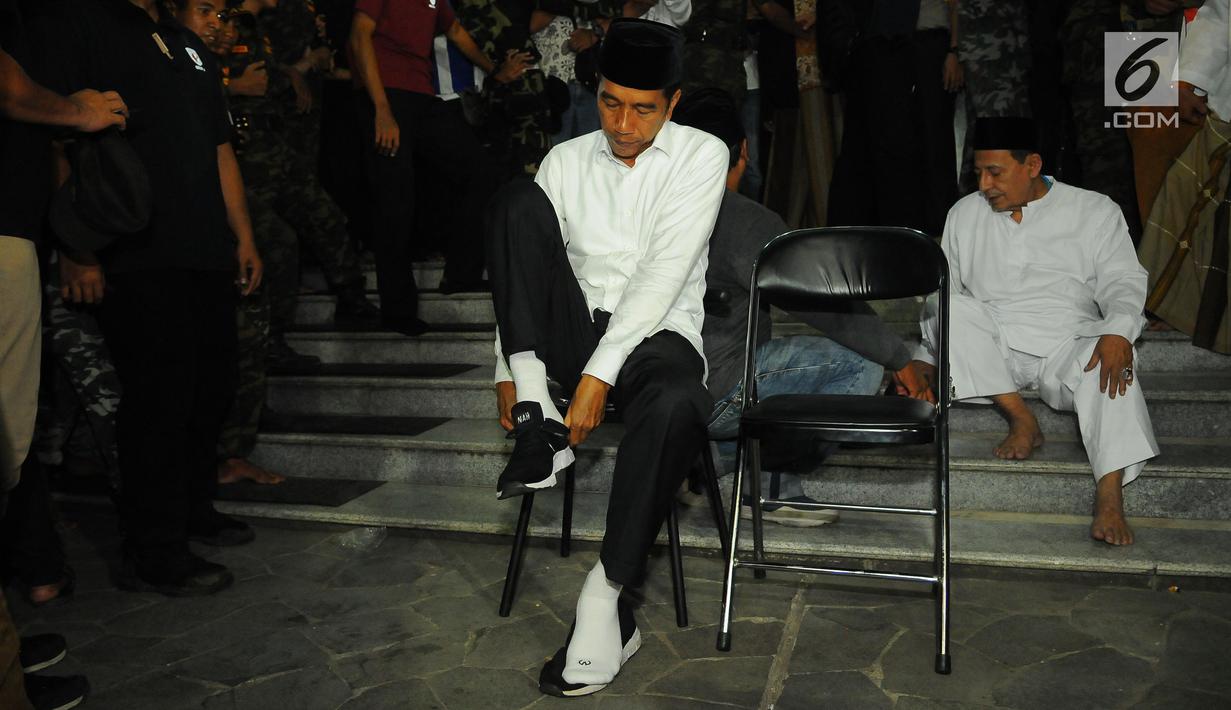 Capres nomor urut 01 Joko Widodo atau Jokowi memakai sepatu usai menjalankan ibadah dalam kampanye terbuka di Alun-Alun Brebes, Jawa Tengah, Kamis (4/4). Jokowi menargetkan kemenangan lebih dari 80 persen di Brebes. (Liputan6.com/Angga Yuniar)