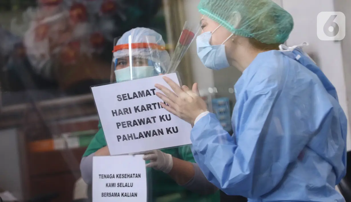 Tenaga medis  mendapatkan bunga mawar dan ucapan selamat Hari Kartini di RSUD Kota Tangerang, Selasa (21/4/2020). Komunitas Taman Potret Tangerang menyambut Hari Kartini dengan mendatangi RSUD Kota Tangerang untuk memberikan bunga dan APD kepada tenaga medis perempuan. (Liputan6.com/Angga Yuniar)