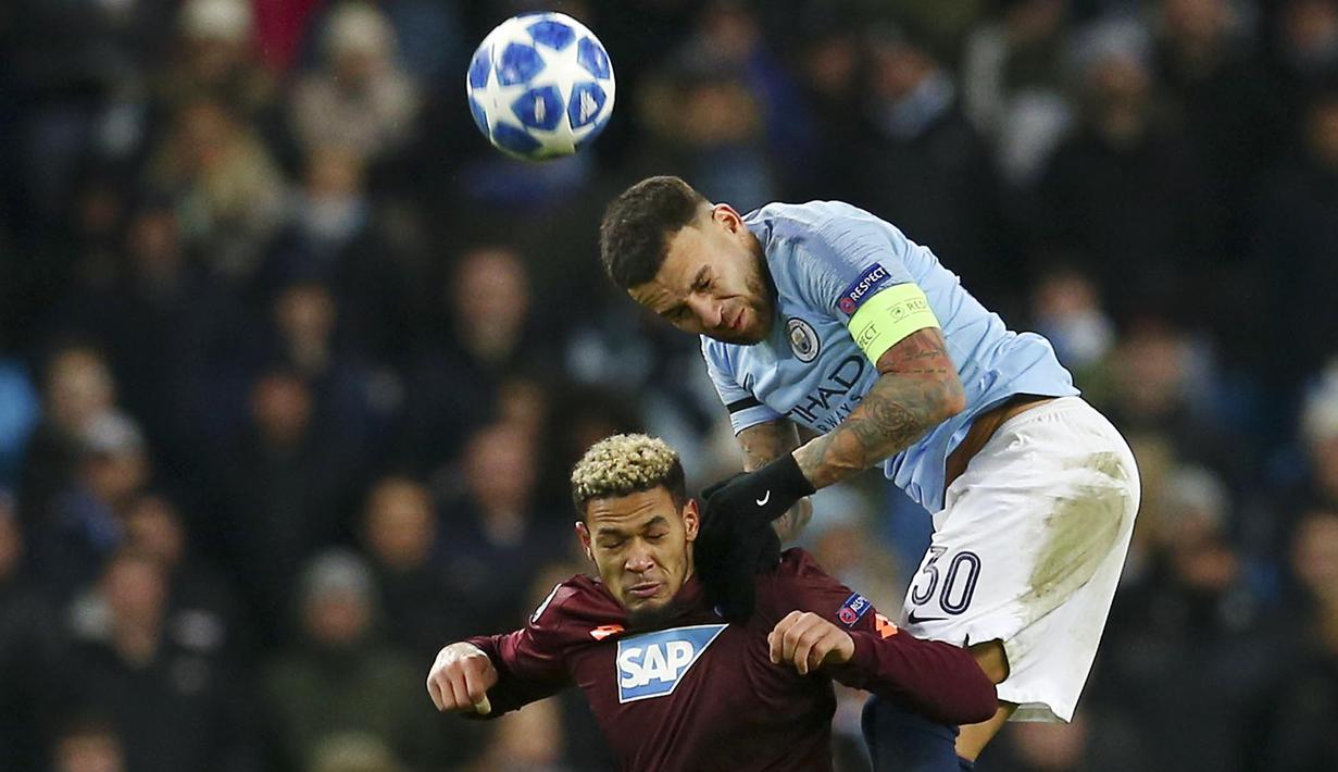Bek Manchester City, Kyle Walker, duel udara dengan striker Hoffenheim, Joelinton, pada laga Liga Champions di Stadion Etihad, Rabu (12/12). Manchester City menang 2-1 atas Hoffenheim. (AP/Dave Thompson)