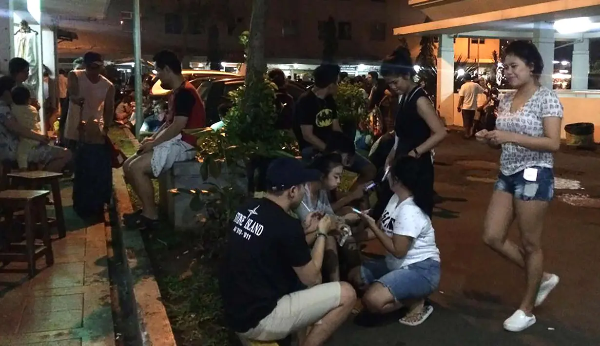 Warga berkumpul di luar apartemen di Jakarta (16/12). Gempa berkekuatan 6,9 SR yang mengguncang Pulau Jawa membuat warga berada di apartemen panik. (AFP Photo/Dessy Sagita)