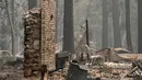 Rumah dan barang-barang pribadi yang terbakar di Dixie Fire masih membara di daerah Indian Falls Plumas County, California (26/7/2021). (AFP/Robyn Beck)
