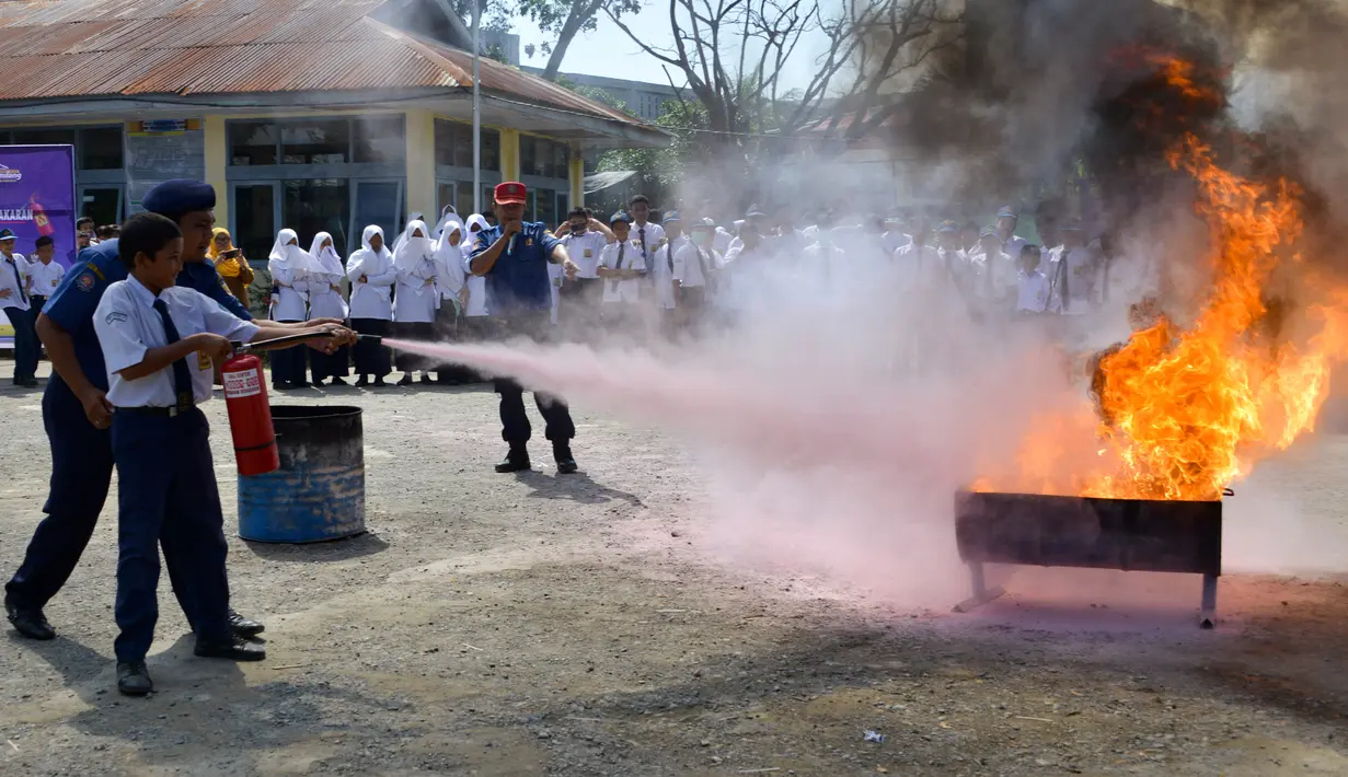Seorang siswa berlatih memadamkan api menggunakan alat pemadam di Banda Aceh, Senin (11/11/2019). Sebanyak 439 pelajar mendapat pembekalan cara pencegahan pemadaman api akibat kebakaran dari petugas Dinas Pemadam Kebakaran dan Penyelamatan Kota Banda Aceh. (CHAIDEER MAHYUDDIN/AFP)