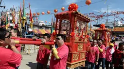 Warga keturunan Thailand-China mengarak kereta kayu yang membawa patung Dewi yang sangat dihormati dari Kuil Chao Mae To Mo saat merayakan festival keagamaan tahunan di distrik Sungai Kolok, Thailand (8/5). (AFP/Madaree Tohlala)