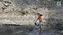 Pekerja dari UPK Badan Air Dinas Kebersihan DKI Jakarta mencangkul endapan lumpur di salah satu sisi Kali Cideng kawasan Epicentrum Kuningan, Jakarta, Kamis (20/6/2019). Pencangkulan ini untuk menghilangkan endapan lumpur dan memperlancar arus air. (Liputan6.com/Helmi Fithriansyah)