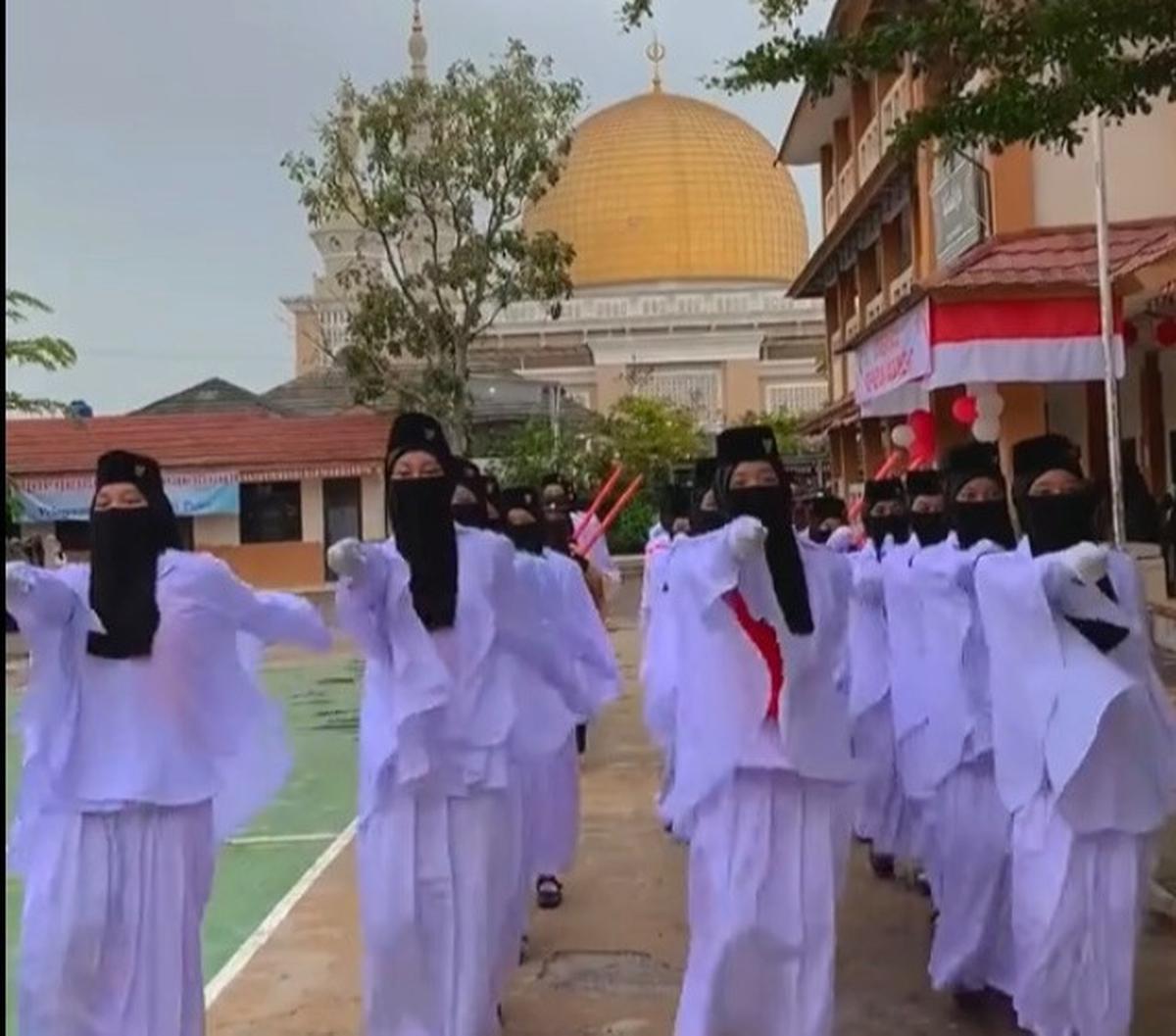 Paskibra ini mengenakan seragam warna putih dengan mamakai cadar warna hitam. Mereka bertugas upacara dengan khidmat.