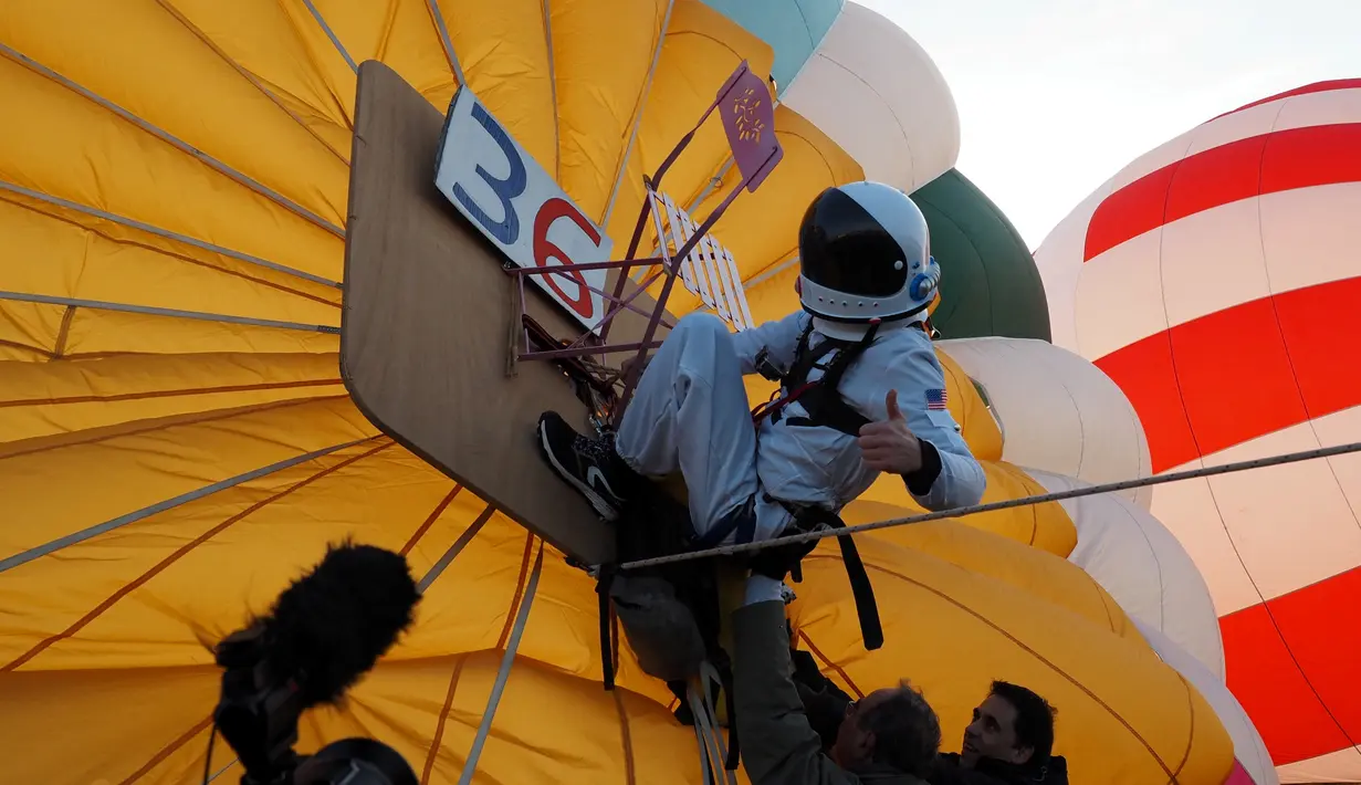 Balonist Prancis Remi Ouvrard bersiap untuk mencoba memecahkan rekor dunia dengan berdiri di atas balon udara panas untuk kampanye Telethon di Chatellerault, Rabu (10/11/2021). Remi Ouvrard berdiri di atas balon udara di ketinggian lebih dari 3637 meter. (Guillaume SOUVANT/AFP)