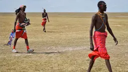 Suku Maasai membawa peralatannya untuk mengikuti pertandingan amal kriket di kaki Gunung Kenya (18/6). Mereka juga berusaha menggalang dana untuk penelitian yang berguna untuk menyelamatkan spesies badak putih. (AFP Phoo/Tony Karumba)