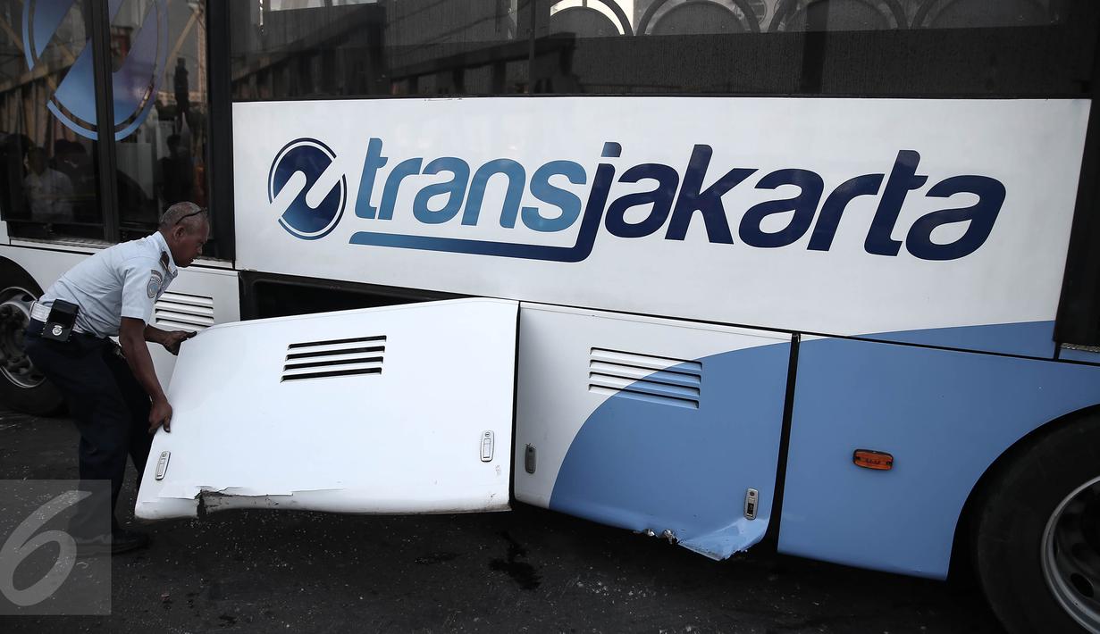 Petugas melihat kondisi bus transjakarta setelah ditabrak kereta Senja Utama Solo di perlintasan Jalan Mangga Dua, Jakarta, Kamis (19/5). Menurut keterangan, insiden itu disebabkan bus Transjakarta yang menerobos palang pintu. (Liputan6.com/Faizal Fanani)