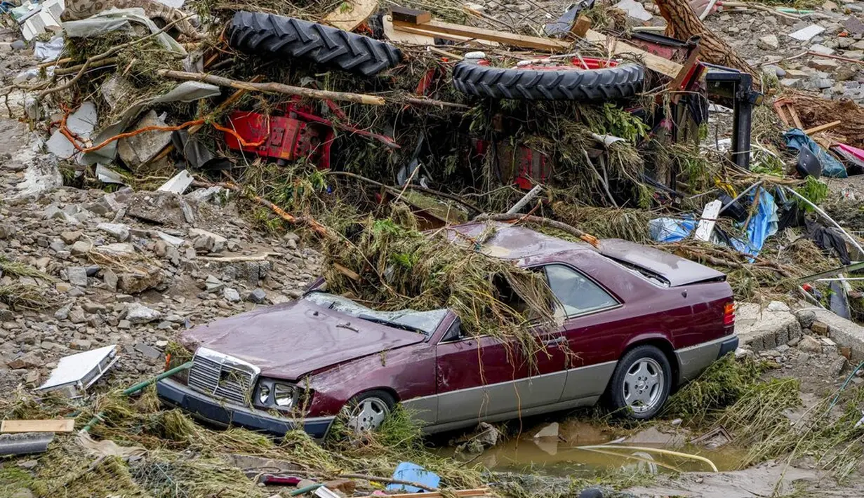 Mobil-mobil hancur terlihat akibat dilanda banjir setelah hujan deras yang turun yang membuat sungai Ahr meluap di Schuld, Jerman, Kamis (15/7/2021). Hujan diprekdiksi akan terus turun dalam beberapa hari ke depan. (AP Photo/Michael Probst)