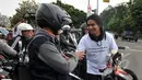 Charli memberikan bunga kepada para pengendara saat 'Aksi Maha Damai' di depan Istana Negara terkait kasus KPK vs Polri bersama Komunitas Anak Bangsa, Jakarta, Selasa (3/2/2015). (Liputan6.com/Panji Diksana)