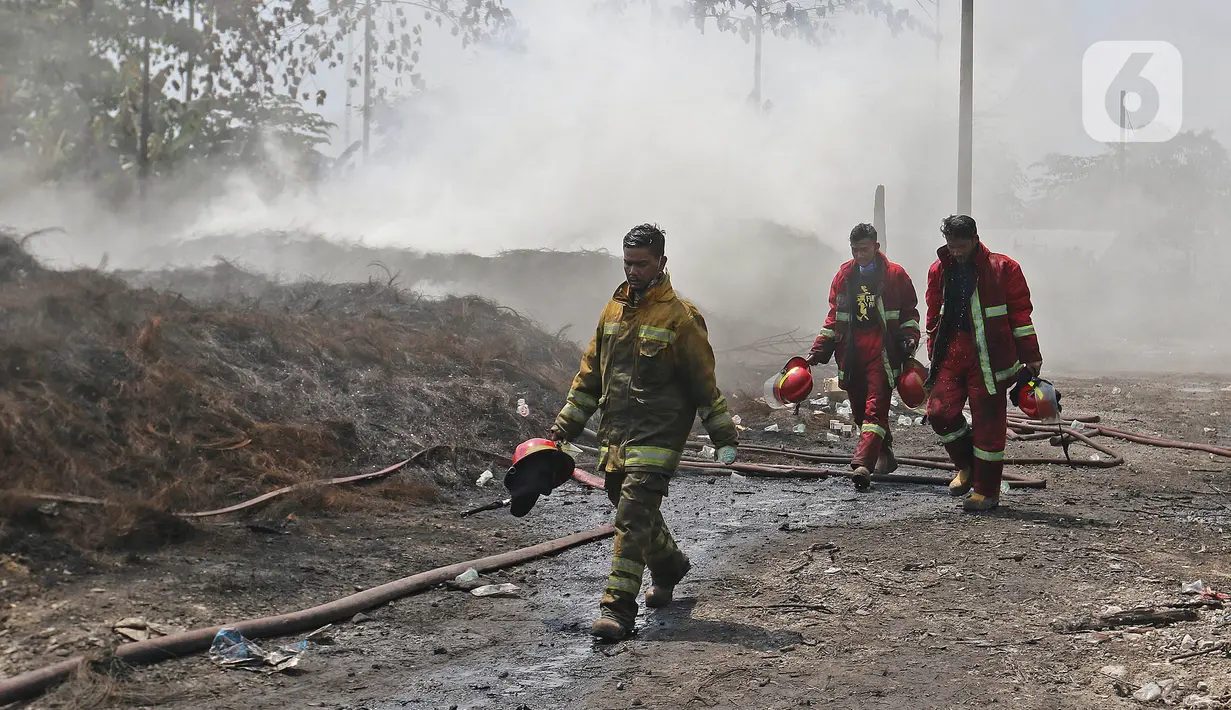 Petugas pemadam kebakaran berjalan usai memadamkan api di lapak ban bekas, Desa Bojong Nangka, Gunung Putri, Bogor, Kamis (22/4/2021). Kebakaran lapak ban bekas yang terjadi Senin (19/4) petang tersebut hingga saat ini belum bisa dipadamkan. (Liputan6.com/Herman Zakharia)
