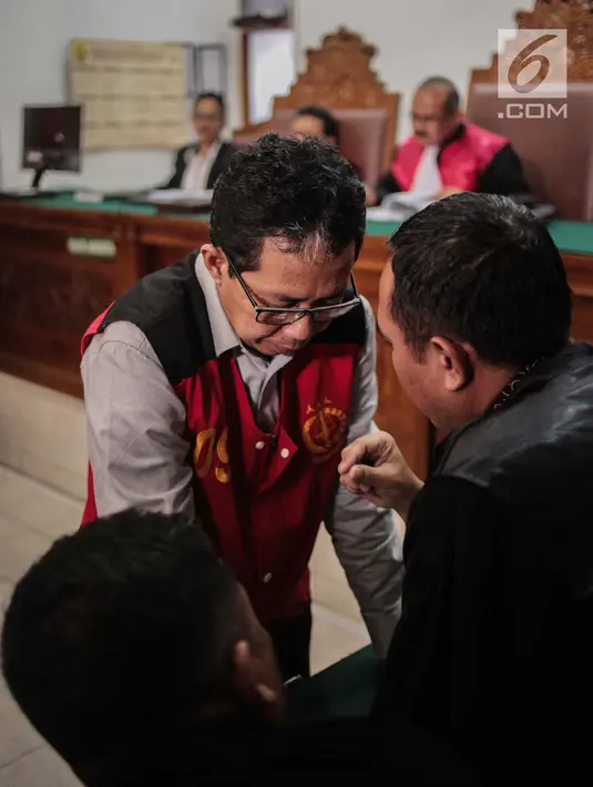 Terdakwa kasus dugaan penghilangan barang bukti pengaturan skor, Joko Driyono berdiskusi dengan kuasa hukum saat sidang putusan di PN Jakarta Selatan, Selasa (23/7/2019). Majelis hakim memvonis mantan Plt Ketua Umum PSSI Joko Driyono 1 tahun 6 bulan penjara. (Liputan6.com/Faizal Fanani)