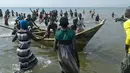 Sejumlah korban selamat dari insiden kapal tenggelam kembali ke darat di Danau Albert, Butiaba, Uganda, Senin (26/12). Setidaknya 30 orang dipastikan menjadi korban dalam insiden tersebut, yang di antaranya terdapat pesepakbola dalam satu tim. (AFP Photo)