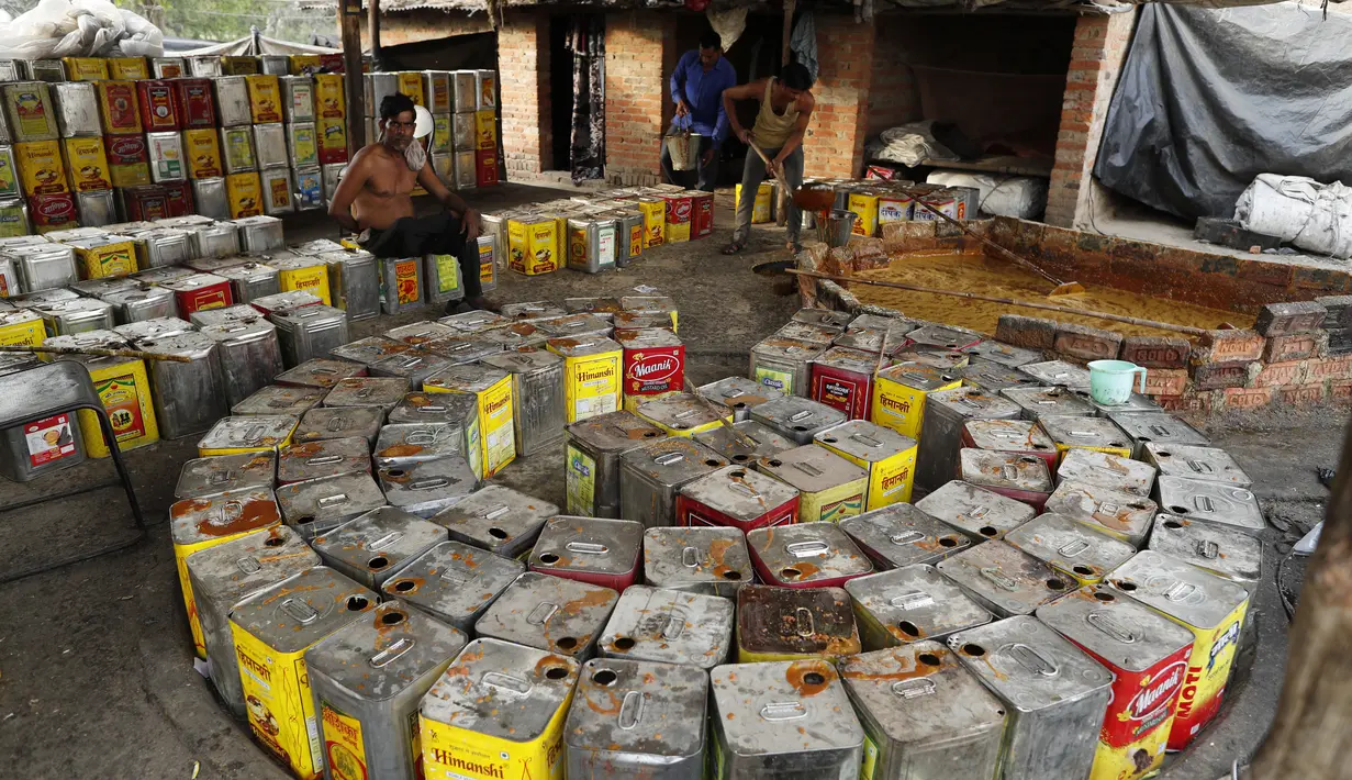 Seorang pekerja mengaduk jus tebu untuk membuat gula merah di pinggiran Bareilly, India, Selasa (23/3/2021).  Jaggery adalah gula tradisional yang tidak dimurnikan yang dikonsumsi di banyak bagian Asia, terbuat dari molase tebu dan nira kurma. (AP Photo/Rajesh Kumar Singh)