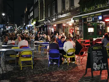 Orang-orang makan dan minum di luar di Soho, di London, Selasa (22/9/2020). Perdana Menteri Inggris, Boris Johnson, telah mengumumkan bahwa pub dan restoran tutup pada pukul 10 malam, karena lonjakan kasus virus corona di seluruh Inggris. (AP Photo / Alberto Pezzali)