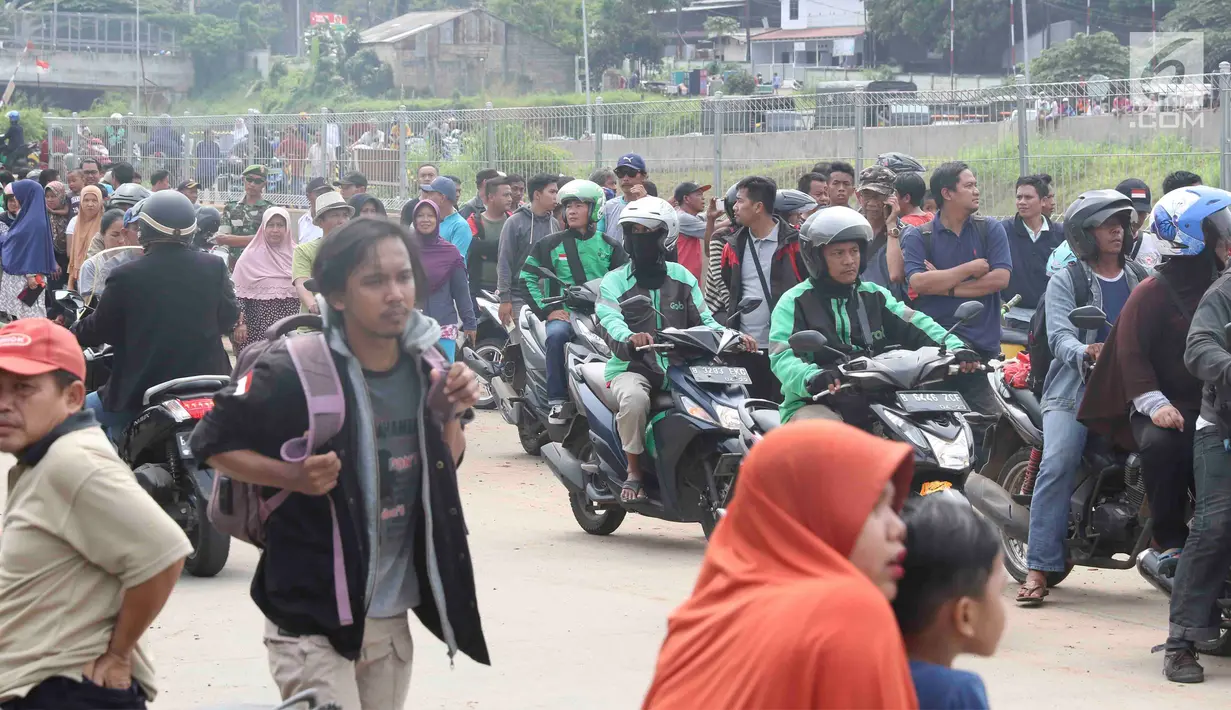 Warga berkerumun menyaksikan eksekusi bangunan rumah milik warga yang terdampak proyek Jalan Tol Cijago di kawasan Kukusan, Depok, Jawa Barat, Rabu (12/12). Di Kukusan, PN Depok kembali mengeksekusi 20 bidang lahan. (Liputan6.com/Immanuel Antonius)