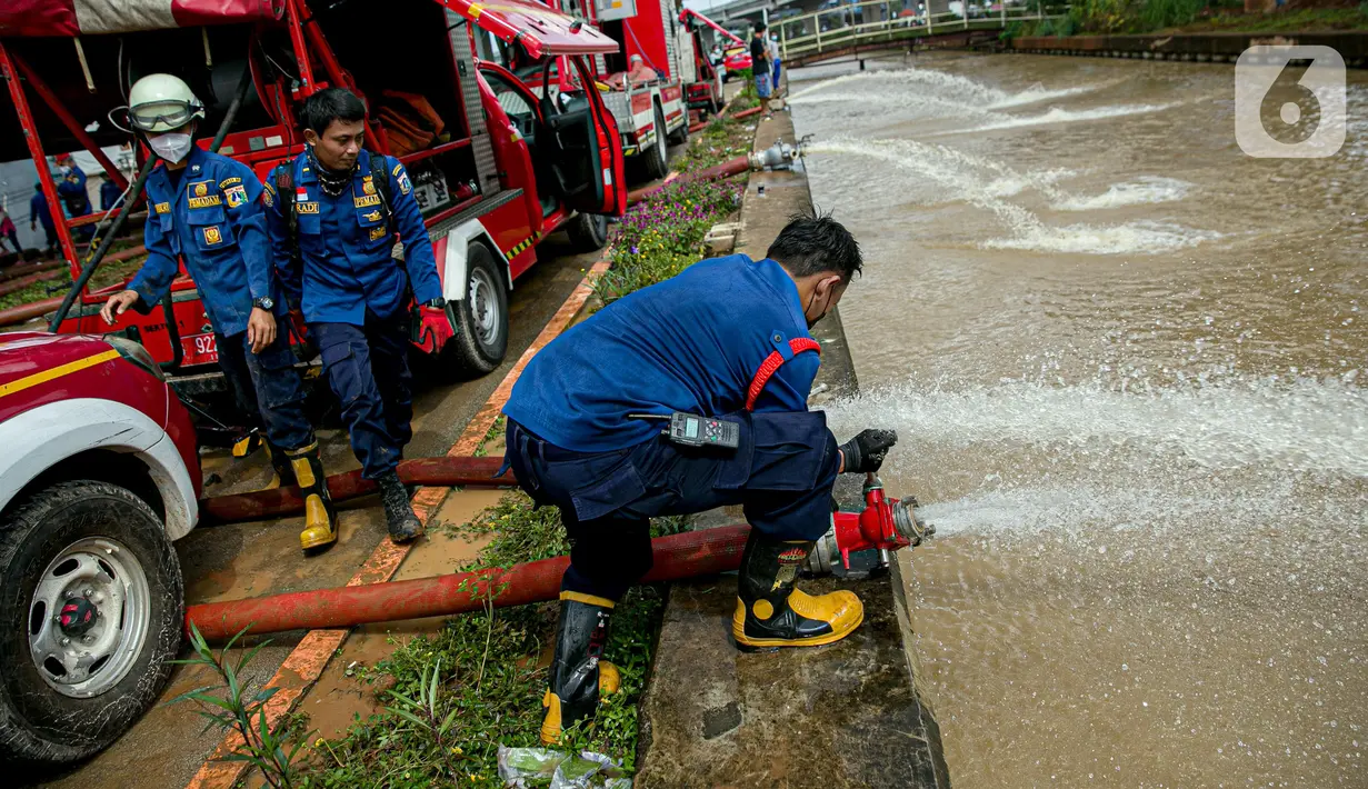 Petugas pemadan kebakaran menyedot air banjir di kawasan Cipinang Melayu, Jakarta, Minggu (21/2/2021). Suku Dinas Pemadam Kebakaran Jakarta Timur mengerahkan 20 mobil pompa untuk menyedot air yang membanjiri RW 04 Kelurahan Cipinang Melayu untuk mengurangi debit air. (Liputan6.com/Faizal Fanani)