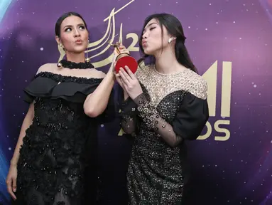 Raisa dan Isyana Sarasvati berfoto usai meraih penghargaan dalam Anugerah Musik Indonesia (AMI) Awards 2017 di Teater Garuda TMII, Jakarta, Kamis (16/11). Raisa dan Isyana meraih penghargaan lewat lagu "Anganku Anganmu". (Liputan6.com/Herman Zakharia)