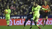 Gelandang Barcelona, Lionel Messi, berebut bola dengan gelandang Levante, Ruben Rochina, pada laga La Liga di Stadion Ciutat de Valencia, Valencia, Minggu (16/12). Levante kalah 0-5 dari Barcelona. (AFP/Jose Jordan)