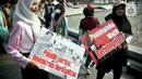 Sejumlah warga membawa poster bertuliskan sosialisasi Pemilu 2024, saat Hari Bebas Kendaraan Bermotor (HBKB) di kawasan Bundaran HI, Jakarta, Minggu (20/8/2023). (Liputan6.com/Johan Tallo)