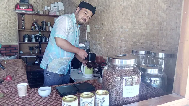 Manager Desa Wisata Ciburial Garut Hadian Hendracahya, tengah menyajikan satu gelas kopi akar wangi Garut