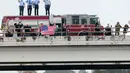 Petugas pemadam kebakaran dan warga memberi hormat saat kereta pembawa peti jenazah Presiden ke-41 AS George HW Bush melintasi Spring, Texas, Kamis (6/12). Bush akan dimakamkan di Museum Perpustakaan Kepresidenan George HW Bush. (AP Photo/Michael Wyke)