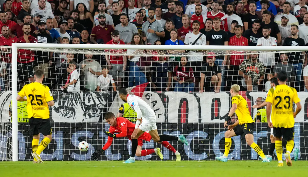 Penjaga gawang Borussia Dortmund Alexander Meyer melakukan penyelamatan saat melawan Sevilla pada pertandingan Grup G Liga Champions di Stadion Ramon Sanchez Pizjuan, Seville, Spanyol, 5 Oktober 2022. Borussia Dortmund menang 4-1. (AP Photo/Jose Breton)