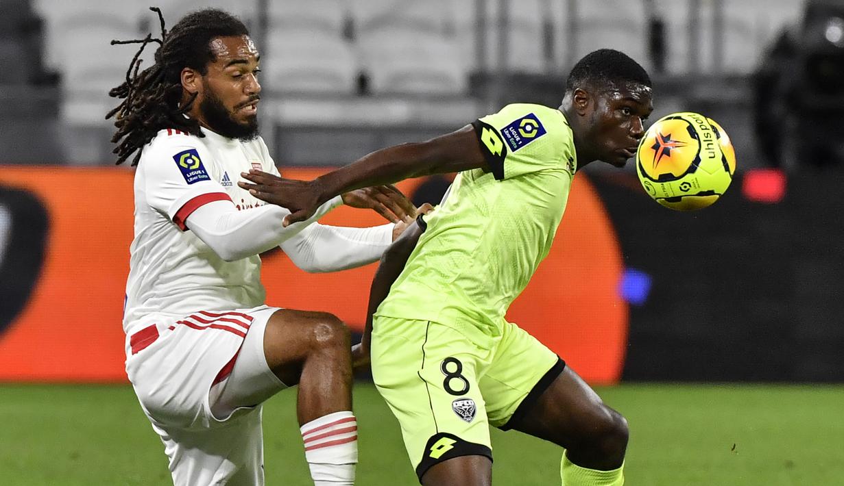 Bek Olympique Lyon, Jason Denayer, berebut bola dengan gelandang Dijon, Eric Junior Dina-Ebimbe, pada laga Ligue 1 di Stadion Groupama, Sabtu (29/8/2020) dini hari WIB. Lyon menang 4-1 atas Dijon. (AFP/Philippe Desmazes)