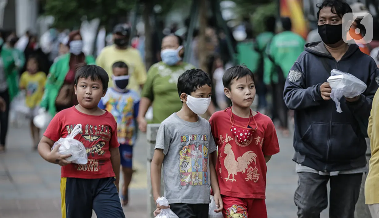 Anak-anak mendapat makanan gratis di Sudirman, Jakarta, Jumat (8/5/2020). Bagi-bagi makanan ini sebagai bentuk kepedulian untuk pengemudi ojol dan warga sekitar yang terdampak kebijakan penanganan virus corona, seperti work frome home dan physical distancing. (Liputan6.com/Faizal Fanani)