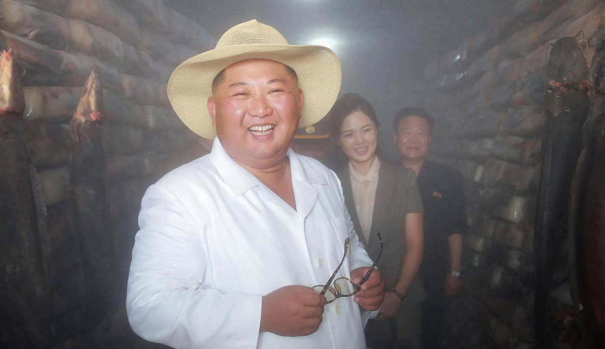 Pemimpin Korea Utara Kim Jong-un (kiri) bersama istrinya Ri Sol-ju (tengah) saat meninjau peternakan lele samchon di Provinsi Hwanghae Selatan, Korea Utara, Senin (6/8). (KCNA VIA KNS/AFP)