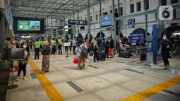 Sejumlah calon penumpang menunggu keberangkatan kereta di Stasiun Pasar Senen, Jakarta, Jumat (24/12/2021). PT Kereta Api Indonesia (KAI) menambah jumlah kereta jarak jauh selama libur Natal dan Tahun Baru. (Liputan6.com/Faizal Fanani)