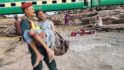 Petugas mengevakuasi seorang penumpang yang terluka dalam kecelakaan dua kereta di distrik Rahim Yar Khan, Pakistan, Kamis (11/7/2019). Kecelakaan terjadi ketika kereta penumpang yang sedang melaju dari arah timur kota Lahore menabrak kereta barang yang berhenti di persimpangan. (Photo by STR / AFP)