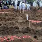 Keluarga menyaksikan pemakaman jenazah korban COVID-19 di TPU Tegal Alur, Jakarta, Kamis (17/12/2020). Hingga hari ini, intensitas pemakamanan korban covid-19 di DKI masih tinggi dengan rata-rata yang dimakamkan mencapai 30 hingga 38 jenazah per hari. (merdeka.com/Arie basuki)