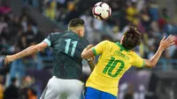 Striker Argentina Lautaro Martinez berjibaku dengan gelandang Brasil Lucas Paqueta pada uji coba di King Saud University Stadium, Jumat (15/11/2019) atau Sabtu dini hari WIB. (AFP/Fayez Nureldine )