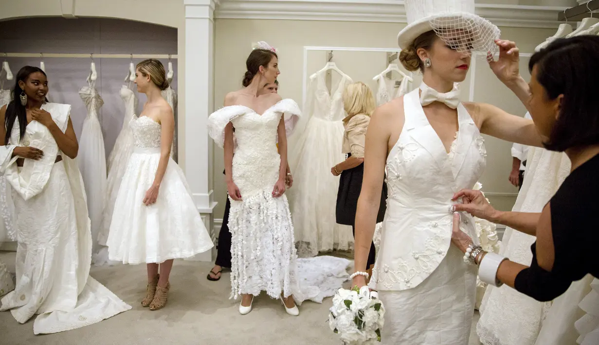 Sejumlah model bersiap jelang kontes gaun pengantin yang terbuat dari tisu toilet di Butik Kleinfled's Bridal, New York, 17 Juni 2015. Peserta hanya diperbolehkan membuat gaun ini dari bahan tisu toilet, lem, jarum dan benang. (REUTERS/Brendan McDermid)