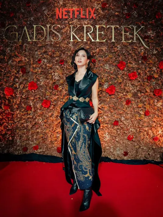 Sheila Dara tampil penuh pesona dengan atasan tanpa lengan dengan detail train panjang di bagian belakang, dipadunya dengan kain batik bernuansa biru navy yang gelap dan serasi. Penampilannya semakin memukau dengan belt ukiran berwarna emas yang dililitkan di atas pinggangnya. Rambut pendeknya diikal dan dibiarkan tergerai, menyempurnakan penampilannya secara keseluruhan. [Foto: Instagram/hagaipakan]