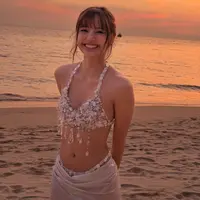 Ia mengenakan bikini top berhias detail kerang, kristal, mutiara, dan untaian manik transparan yang menjuntai di bagian bawah. [@lalalalisa_m].