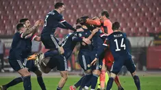 Pemain Skotlandia merayakan kemenangan atas Serbia pada babak playoff Piala Eropa 2020 di Red Star Stadium, Jumat (13/11/2020) dini hari WIB. Skotlandia menang 5-4 atas Serbia lewat adu penalti. (AFP/Andrej Isakovic)