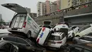 Orang-orang melihat mobil-mobil yang terendam banjir setelah hujan lebat melanda Zhengzhou di provinsi Henan, China, Kamis (22/7/2021). Para peramal cuaca mengatakan Zhengzhou mendapat curah hujan dalam setahun hanya dalam tiga hari. (Noel Celis/AFP)