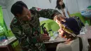 Tim medis dari satuan tugas militer Indonesia memeriksa seorang pasien di rumah sakit setempat di Agats, Asmat, provinsi Papua Barat (26/1). (AFP/Bay Ismoyo)