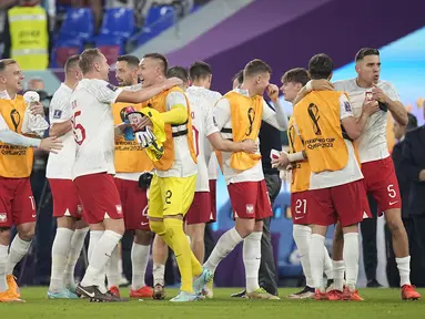 Reaksi gembira para pemain Polandia setelah lolos ke babak 16 besar Piala Dunia 2022 meski kalah dengan skor 0-2 dari Argentina pada matchday ketiga Grup C yang berlangsung di Stadion 974, Doha, Kamis (01/12/2022). (AP/Ariel Schalit)