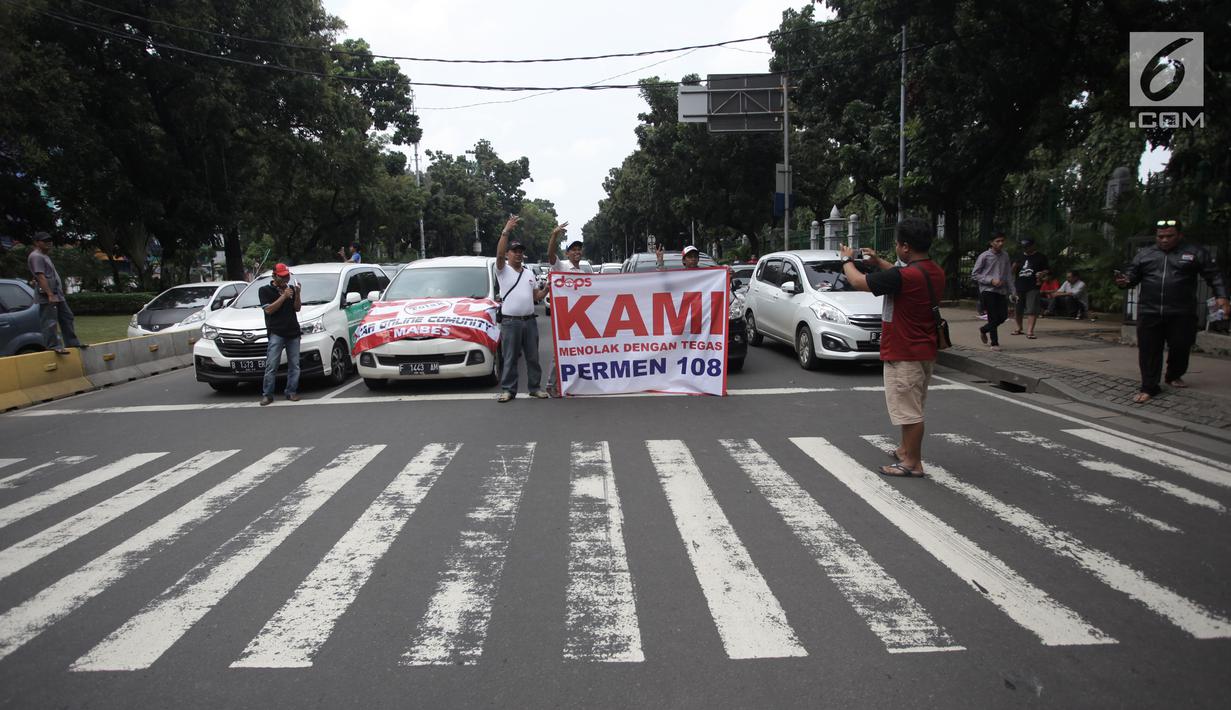 Aksi demo ratusan mobil sopir taksi online di Jalan Medan Merdeka Barat, Jakarta, Rabu (14/2). Para pengemudi meminta Menteri Perhubungan Budi Karya untuk menghapus Permenhub Nomor 108 Tahun 2017. (Liputan6.com/Arya Manggala)
