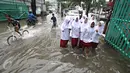 Sejumlah anak berusaha menerobos banjir yang merendam Jalan Panjang, Jakarta Barat, Jumat (26/2). Hujan yang mengguyur wilayah Jakarta membuat sejumlah titik terendam banjir dengan ketinggian sekitar 20 cm hingga 1 meter. (Liputan6.com/ Immanuel Antonius)