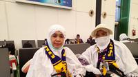 Anisah Naharuddin Palussai (tak ditutup masker) ditemani Ely Rahmini Musa menunggu jadwal penerbangan di paviliun Bandara Internasional King Abdulaziz Jeddah, Sabtu, 14 Juni 2025. (dok. Liputan6.com/Dinny Mutiah/MCH 2025)
