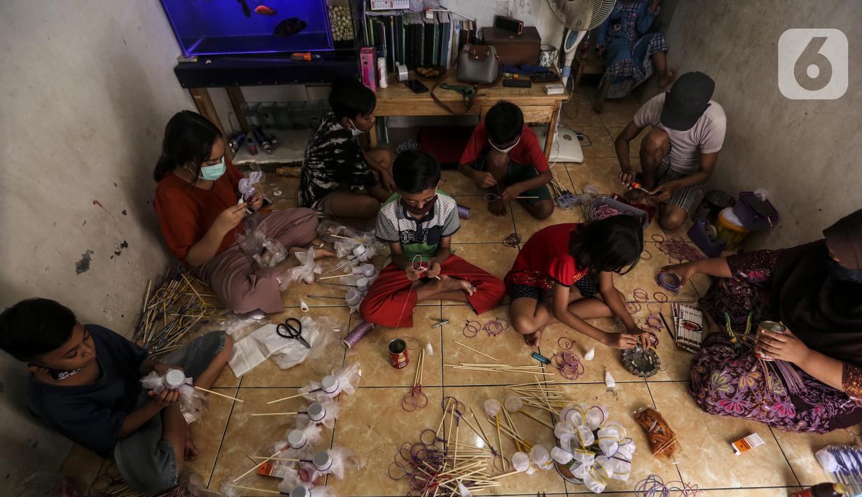 Anak-anak membuat serokan ikan cupang di rumah kontrakan Udin, Sukabumi Selatan, Jakarta Barat, Selasa (22/12/2020). Dalam sehari, Udin sanggup membuat serokan ikan cupang sebanyak 400 buah. (Liputan6.com/Johan Tallo)