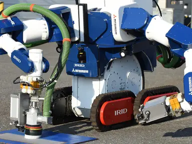 Sebuah unit robot dikendalikan dari jarak jauh untuk menghilangkan serbuk besi akibat ledakan nuklir saat demonstrasi di Chiba, Jepang (16/12). Robot dikembangkan untuk pembangkit nuklir Fukushima yang mengalami krisis sejak Tsunami. (AFP/Toru Yamanaka)
