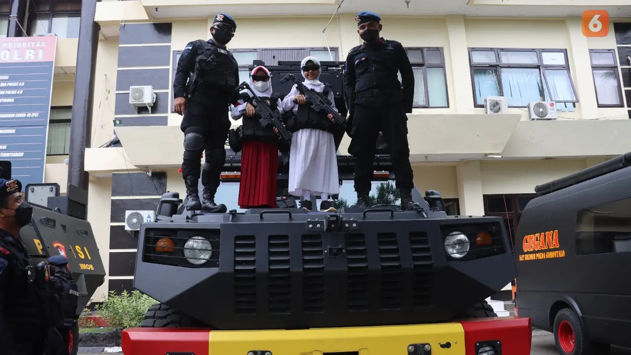 Anak Usia 6-11 usai divaksin antusias berfoto di mobil tempur Brimob Polda Gorontalo (Arfandi/Liputan6.com)
