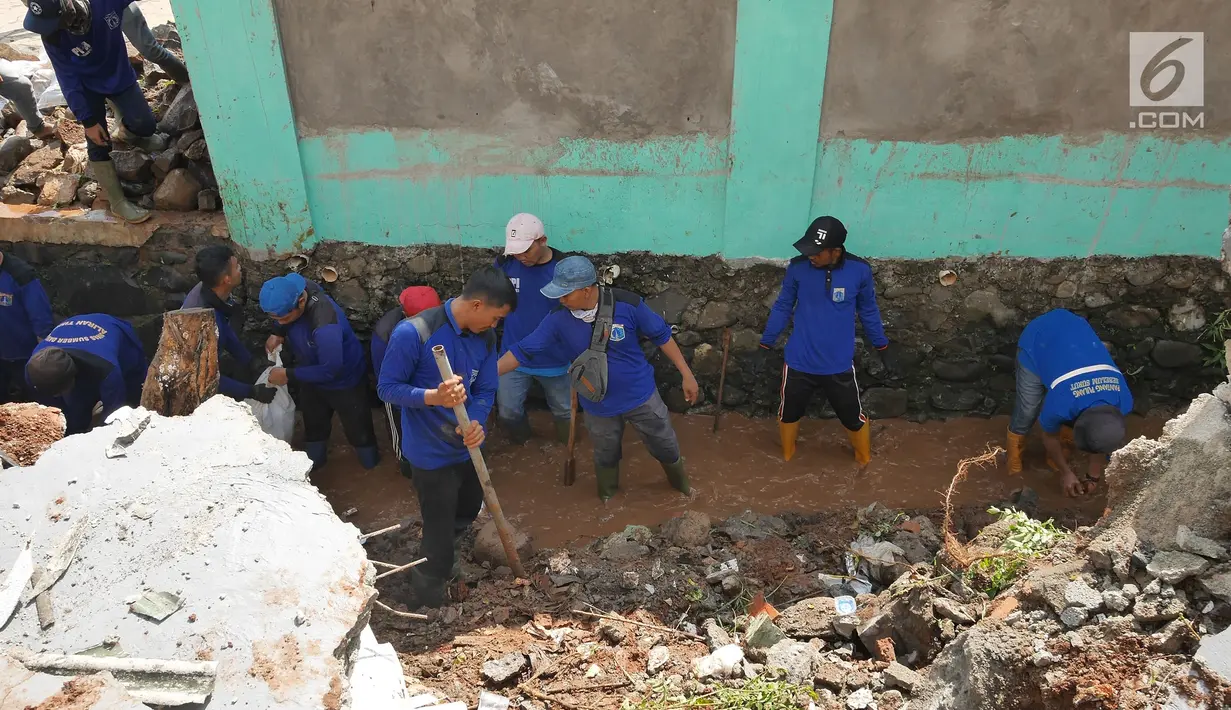 Petugas gabungan membersihkan puing-puing longsoran di Perumahan Pesona Kalisari, Pasar Rebo, Jakarta, Selasa (27/11). Ekskavator turut dikerahkan untuk membersihkan puing-puing dan tumpukan tanah yang menutupi jalanan. (Liputan6.com/Herman Zakharia)